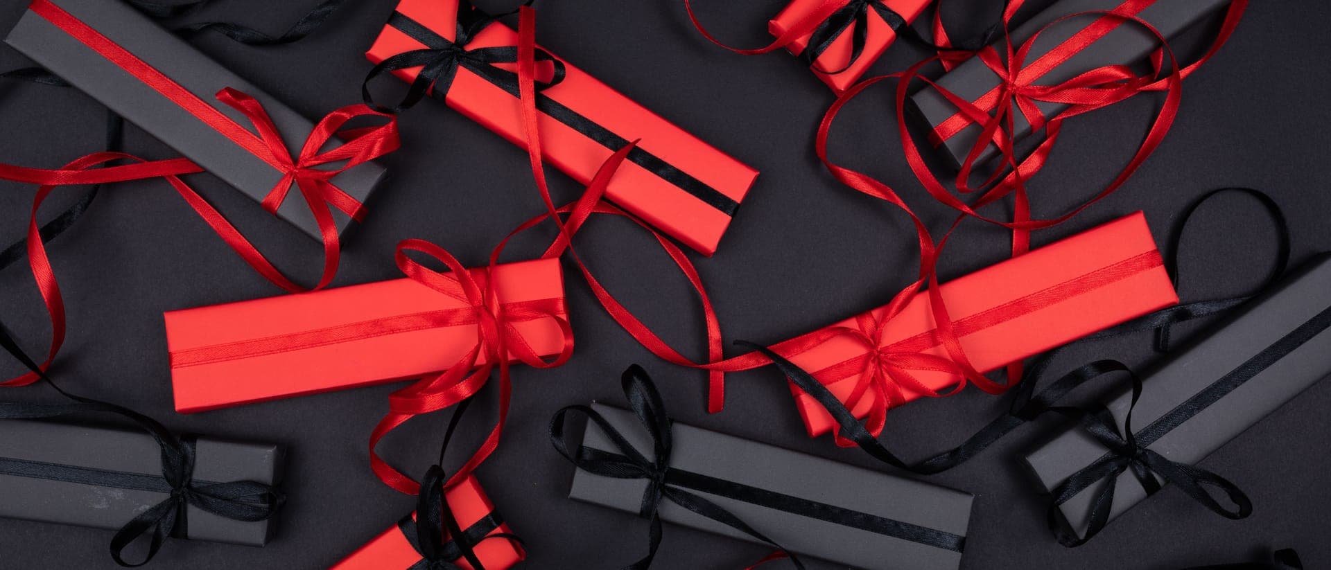 Wrapped gift boxes with ribbon arranged on a pale surface