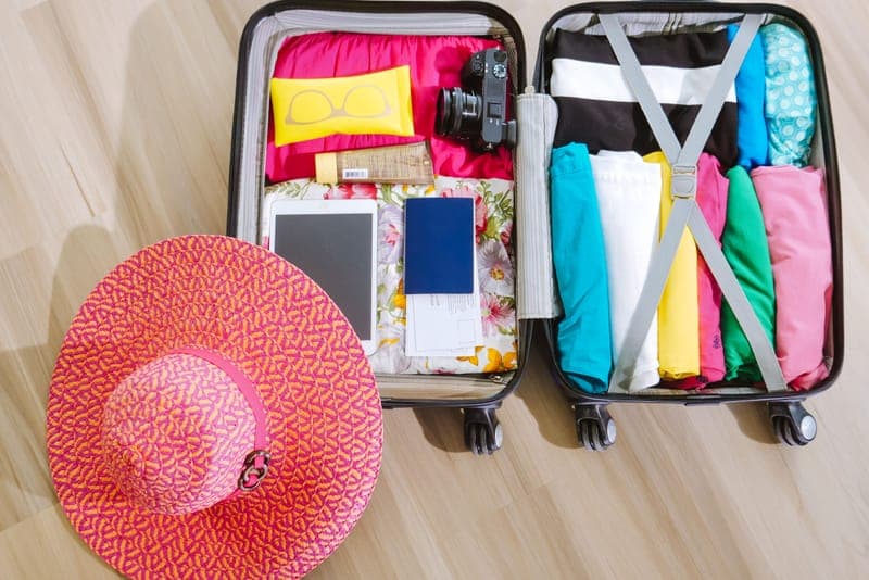 An open suitcase packed with travel essentials
