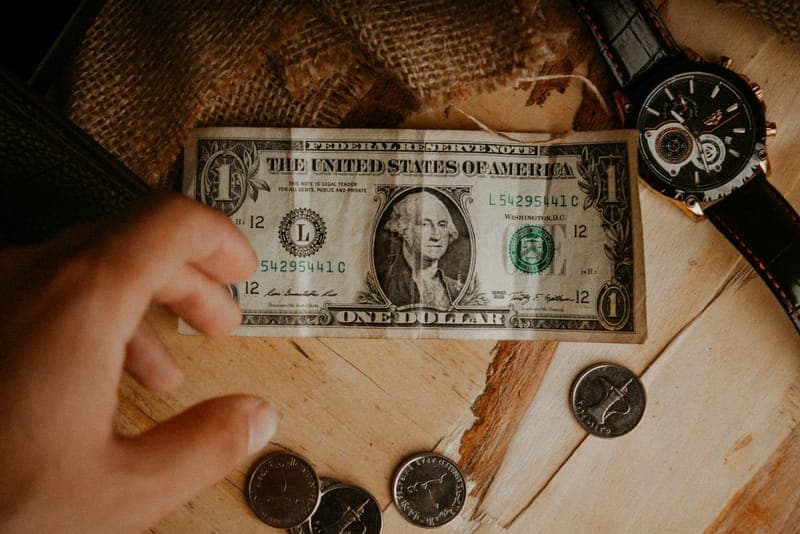 A wristwatch beside a small stack of coins